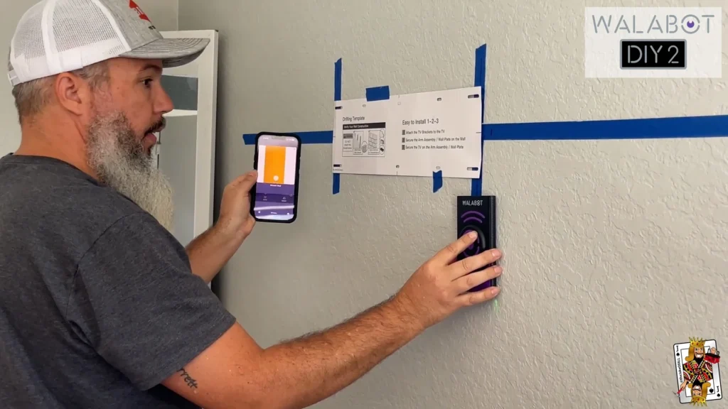 A man uses a Walabot DIY 2 stud finder