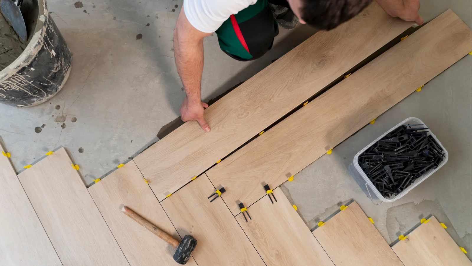Worker installing wood-look floor tiles
