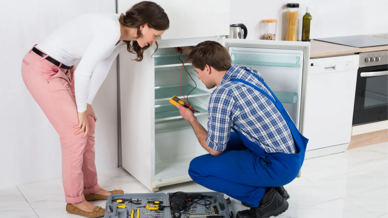 A technician diagnosing a refrigerator issue with tools, helpful if you can’t remove ice maker from Samsung refrigerator safely.
