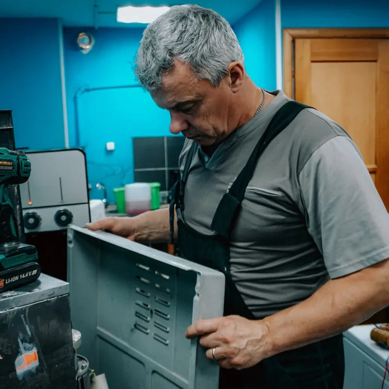Technician servicing a commercial appliance panel