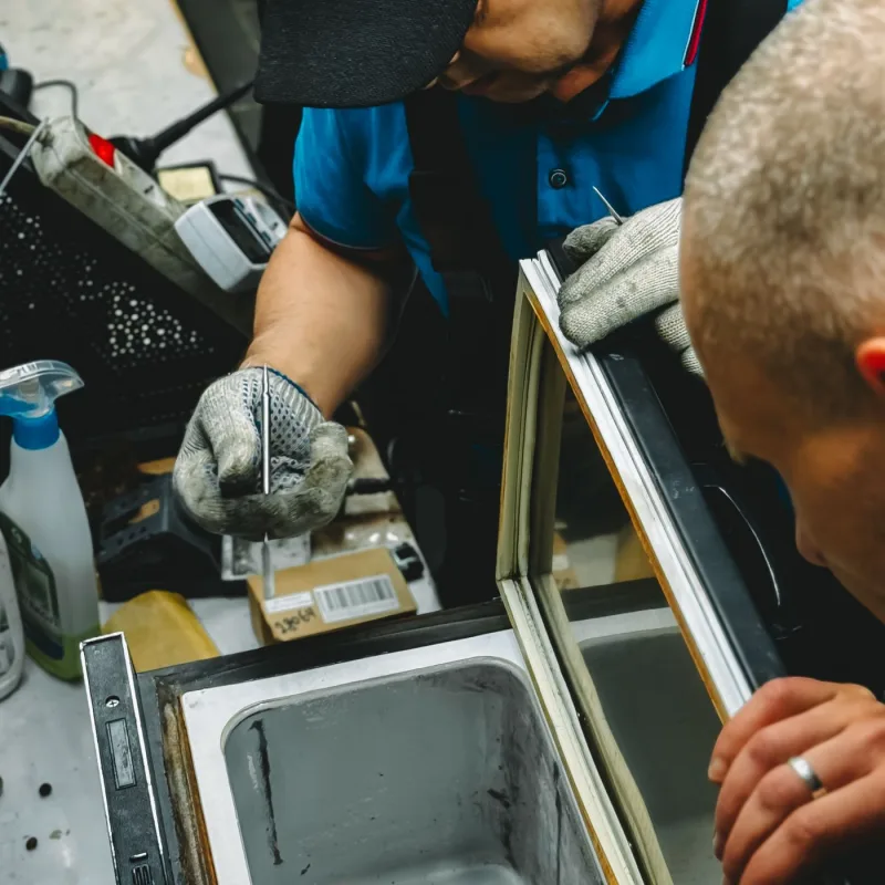 Technicians repairing a commercial freezer unit
